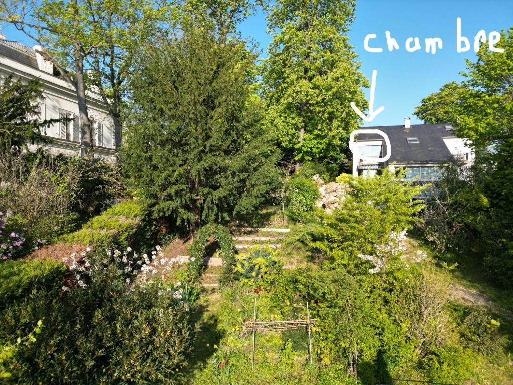 vistas a un jardín con una cabaña en el fondo en Pousada Bertin en Chatou