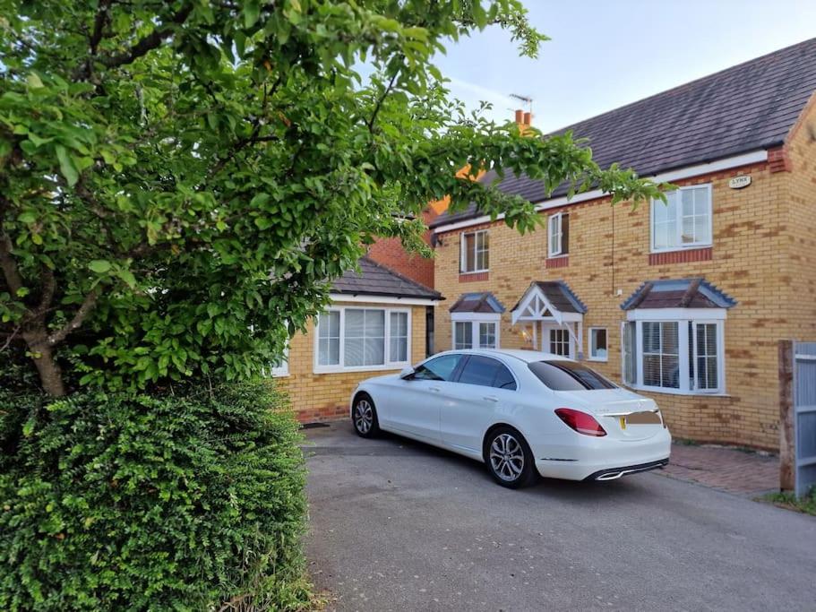 a white car parked in front of a house at Silverstone Stays in Wootton