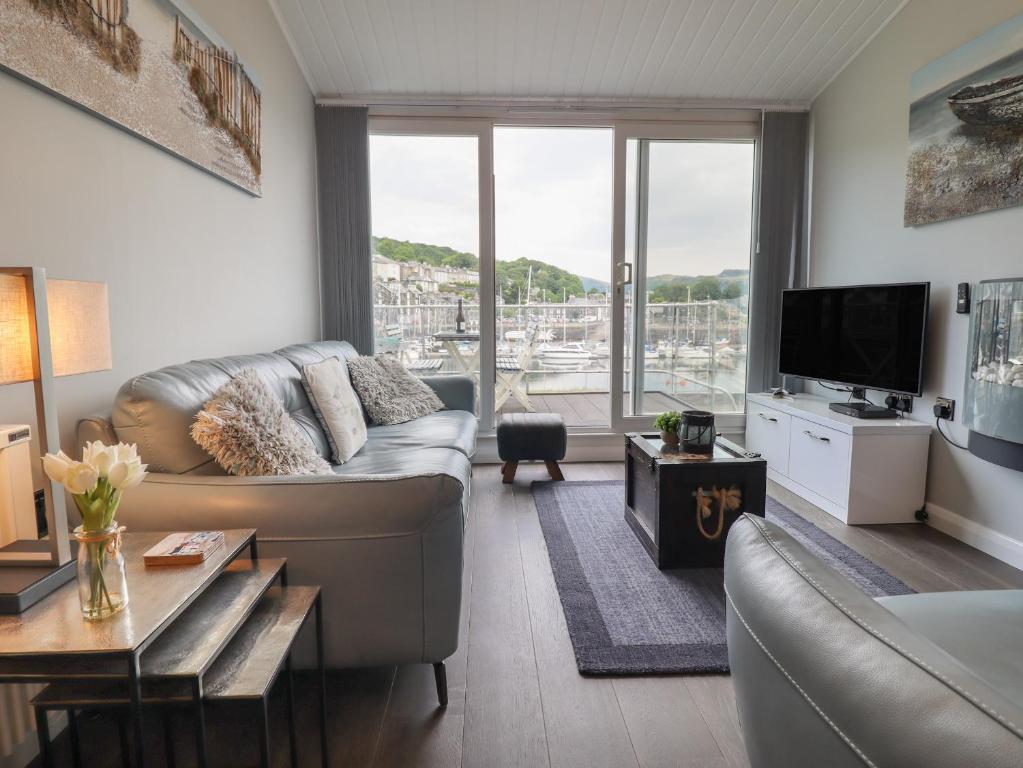 a living room with a couch and a tv at Moelwyn 57D South Snowdon Wharf in Porthmadog
