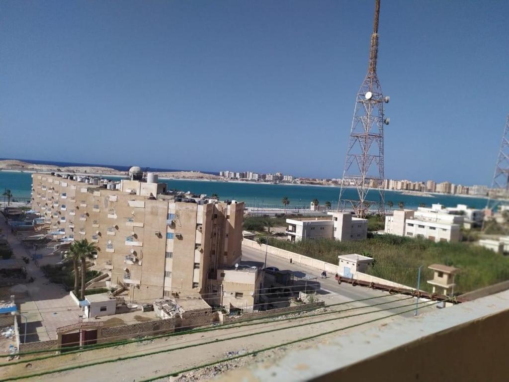 a view of a city with buildings and the ocean at برج حرة الفيروز ( منطقة الاذاعة والتليفزيون الفيروز) in Marsa Matruh