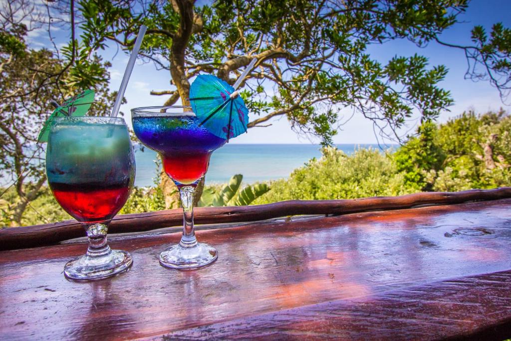 two wine glasses sitting on top of a wooden table at Imvubu Lodge in Richards Bay