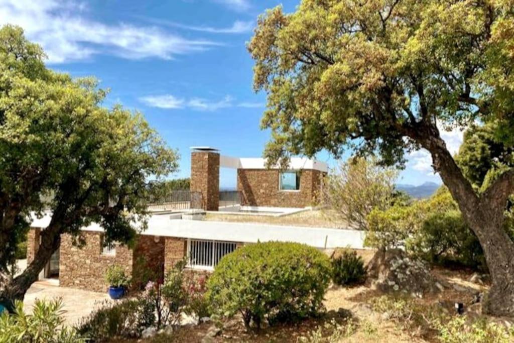 a brick house with trees in front of it at Eole, villa d'architecte, vue mer, piscine in Bormes-les-Mimosas