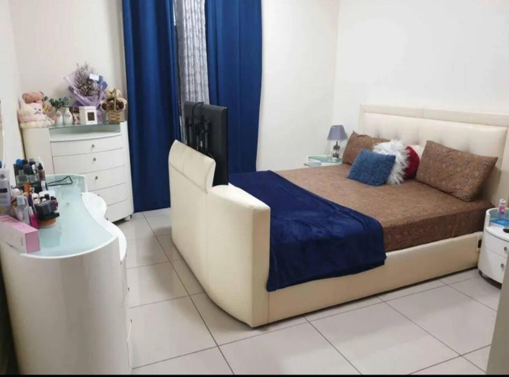 a bedroom with a large bed and a table at One BHK in Ajman 