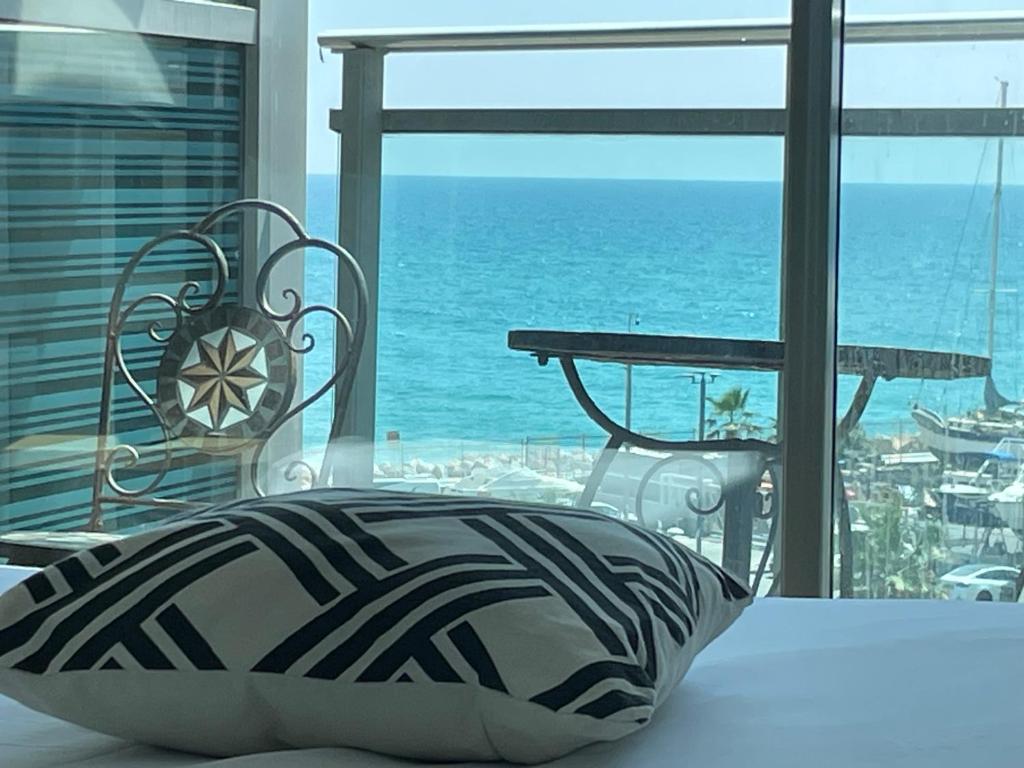 a bedroom with a bed and a view of the ocean at אוקיינוס במרינה מלון דירות בעלים פרטיים עם נוף לים מרפסת אחד עד שני חדרי שינה וסלון in Herzliyya B