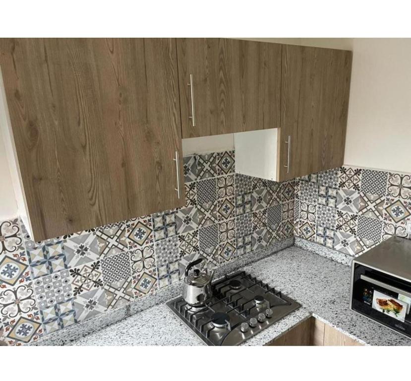 uma cozinha com um fogão e uma parede em azulejo em Résidence Miftah Sahil Anza em Agadir