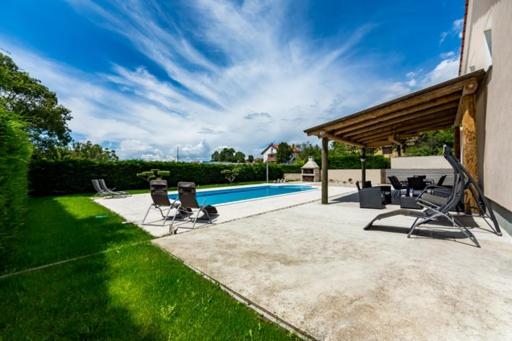 een terras met stoelen en een zwembad bij KARLO in Čavle