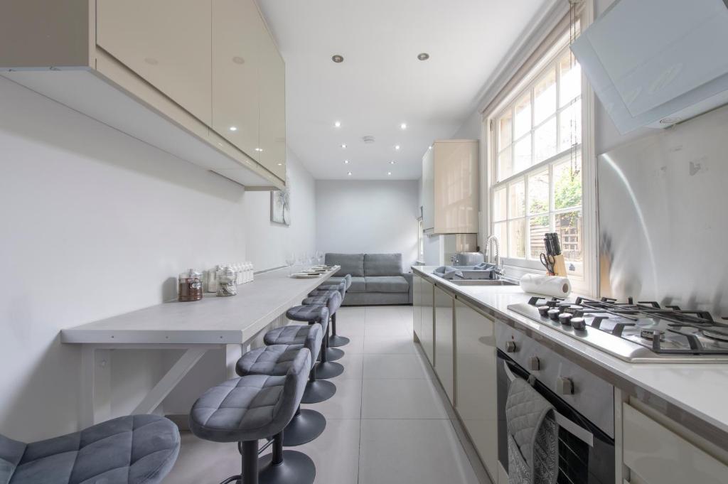 a kitchen with a stove and some chairs in it at Charming Character House London in London