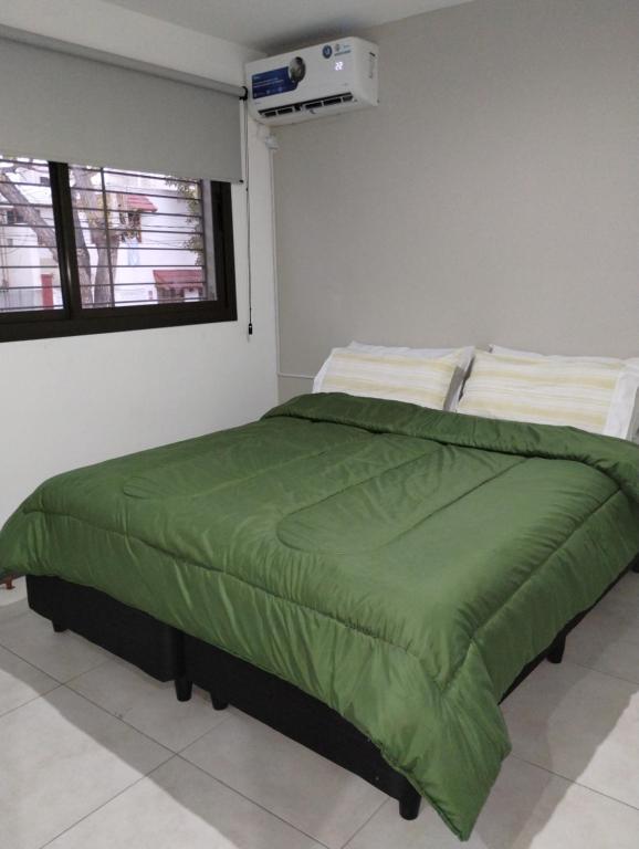 1 dormitorio con edredón verde en la cama en Departamento Renato Zanzin en Godoy Cruz