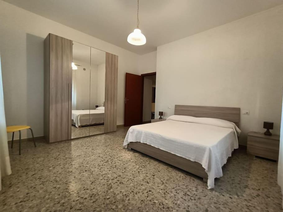 1 dormitorio con 1 cama grande y espejo en Appartamento luminoso in zona centrale, en Montesilvano