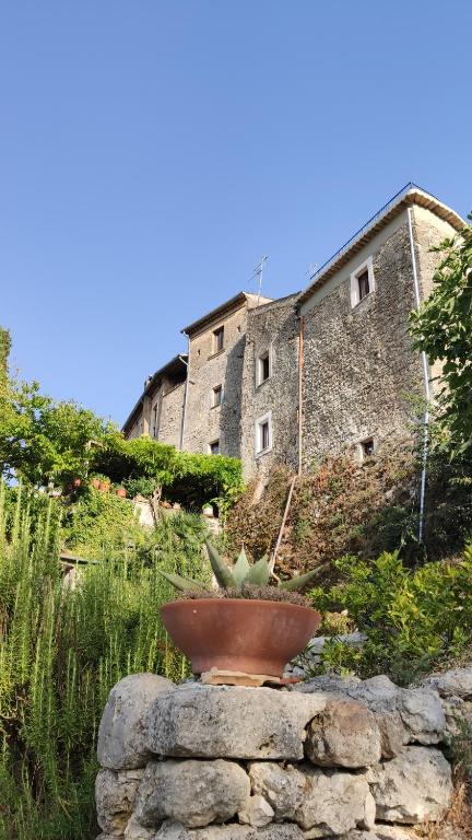 un planteur assis sur un mur en pierre devant un bâtiment dans l'établissement Casa Marianna, à Fontechiari