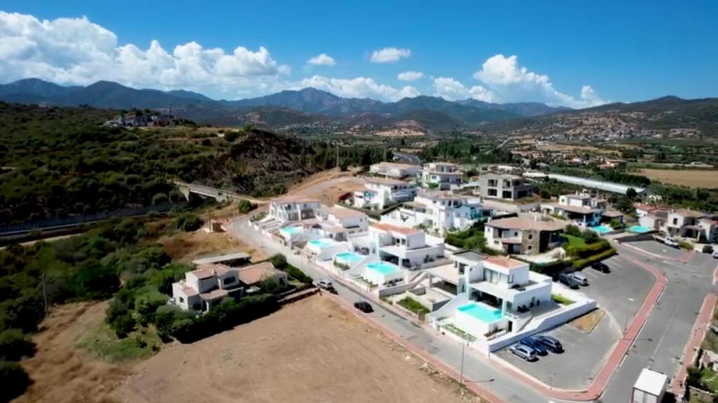 une vue aérienne sur un groupe de maisons blanches dans l'établissement Villa con piscina privata BudoniAffitti, à Budoni