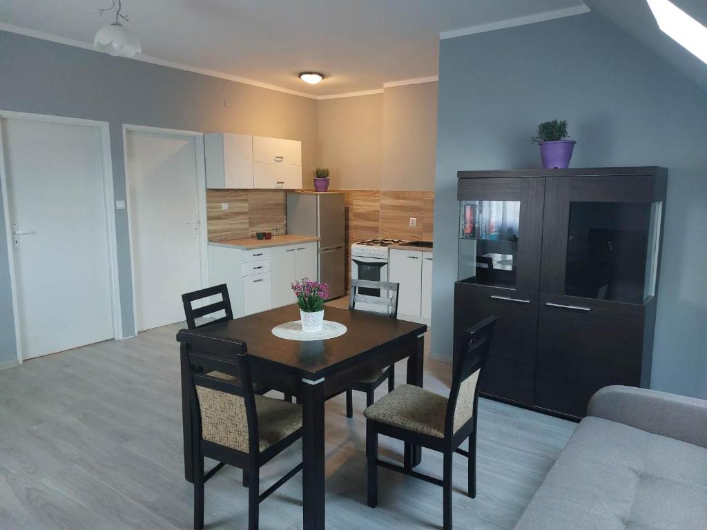 a kitchen and dining room with a table and chairs at Jagodzianka in Miłki