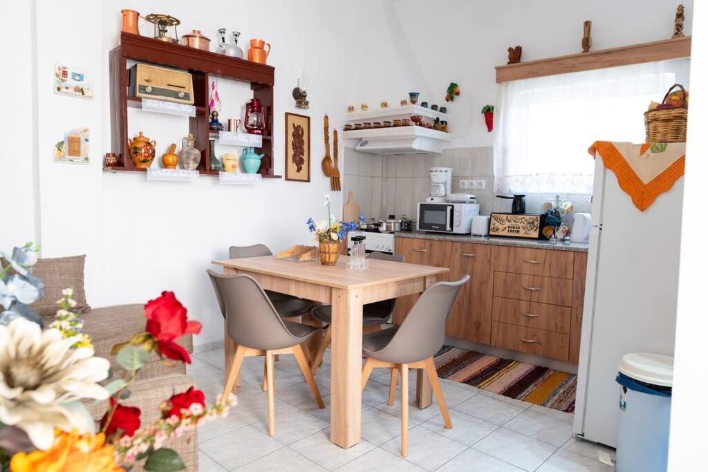 uma cozinha com uma mesa de madeira e cadeiras em Zografia - Charming House near the coast em Cós