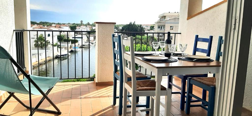 een tafel op een balkon met uitzicht op het water bij Appartement vue exceptionnelle sur les canaux - Wi-Fi fibre haut débit in Empuriabrava