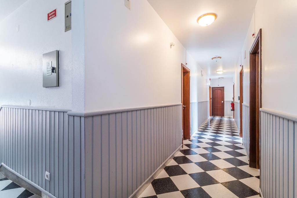 a hallway with a black and white checkered floor at Guesthouse Aljezur Center in Aljezur