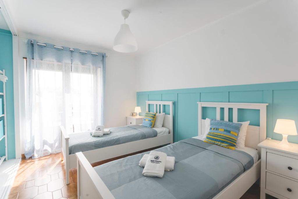 2 camas en una habitación de color azul y blanco en Best Houses 49 - Tiago´s Surf Beach House, en Atouguia da Baleia