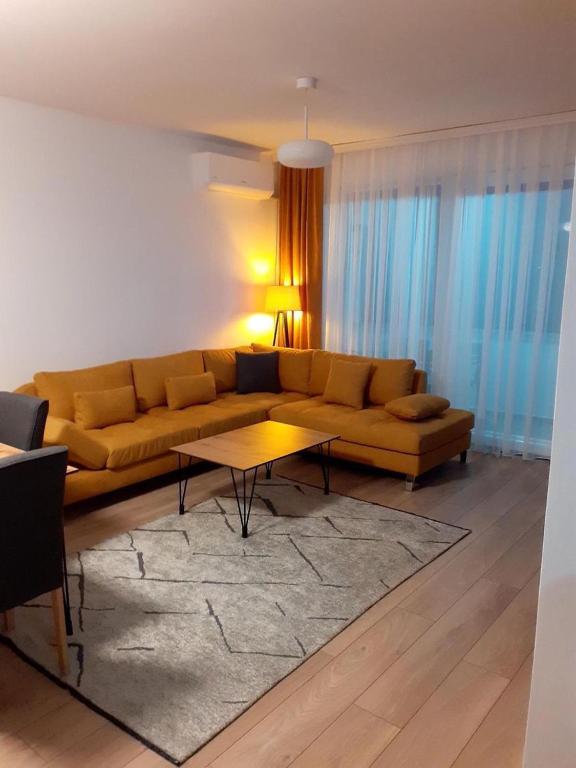 sala de estar con sofá amarillo y mesa en Banesa ne qender te Pejes, en Peje