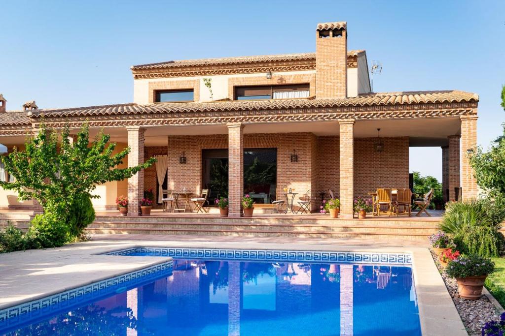 una casa con piscina frente a ella en Villa Marín Toledo en Las Nieves