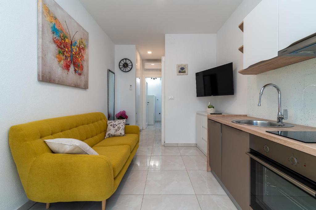 a living room with a yellow couch in a kitchen at Apartment Leo in Trogir