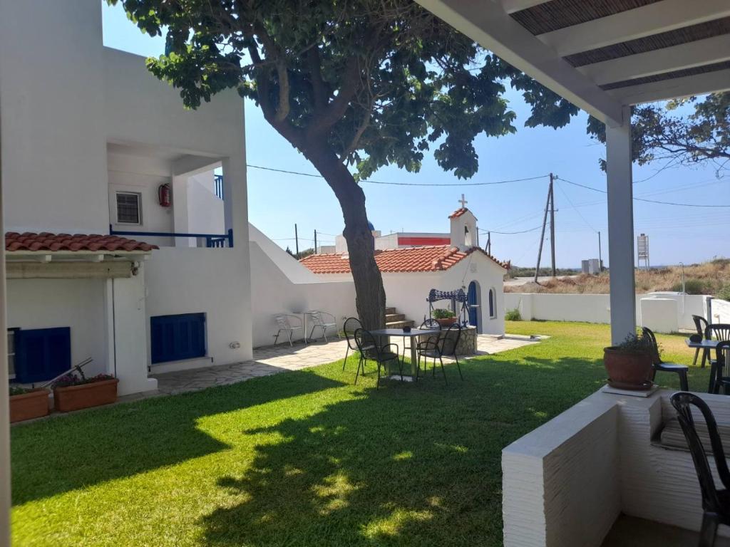 a yard with a tree and a table and chairs at RESTIA in Agios Petros