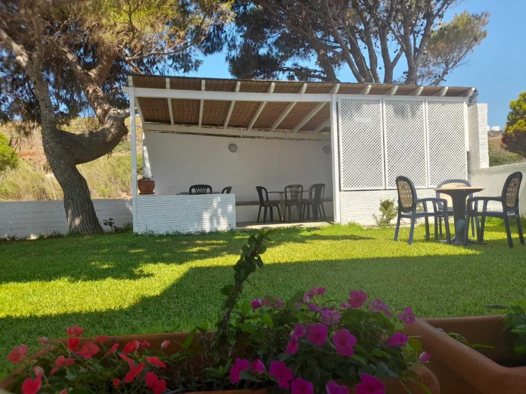 a patio with a table and chairs in a yard at RESTIA in Agios Petros