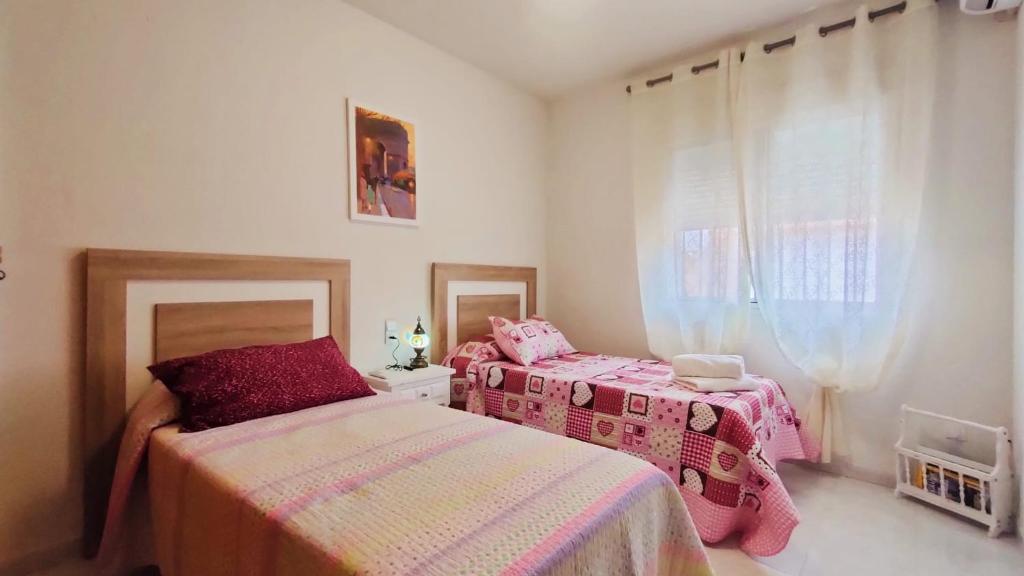 een slaapkamer met 2 bedden en een raam bij Casa Rosales Toledo a 10 minutos de Puy du Fou in Polán