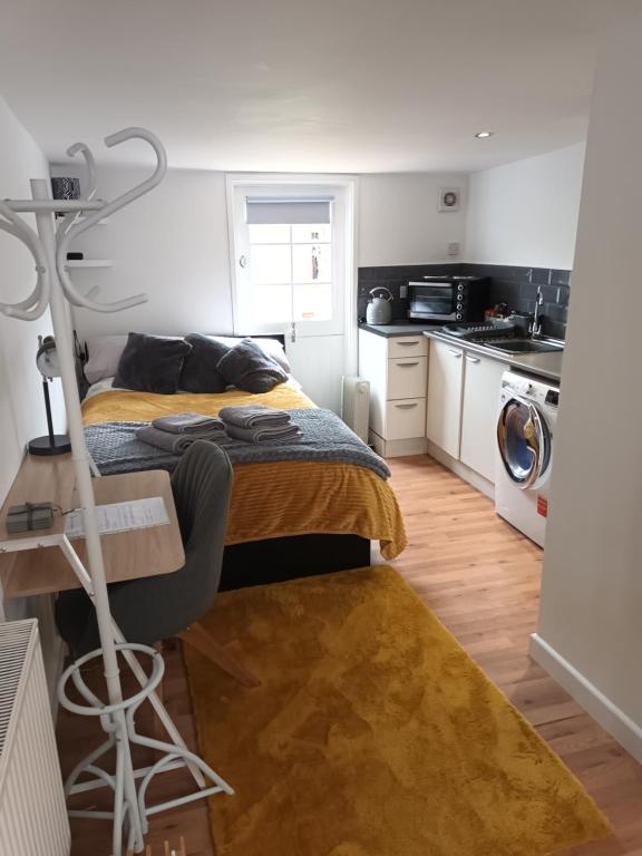 a bedroom with a bed and a kitchen at The Annexe in Rothwell