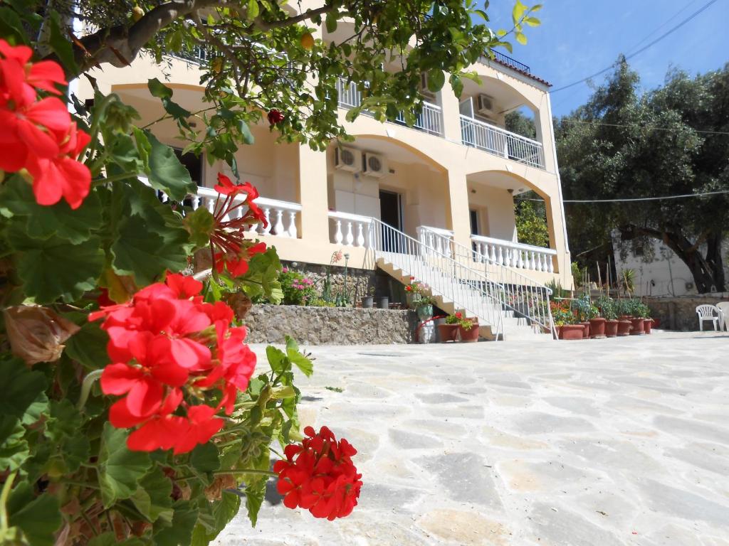 a house with red flowers in front of it at Gregory's Studios in Paleokastritsa