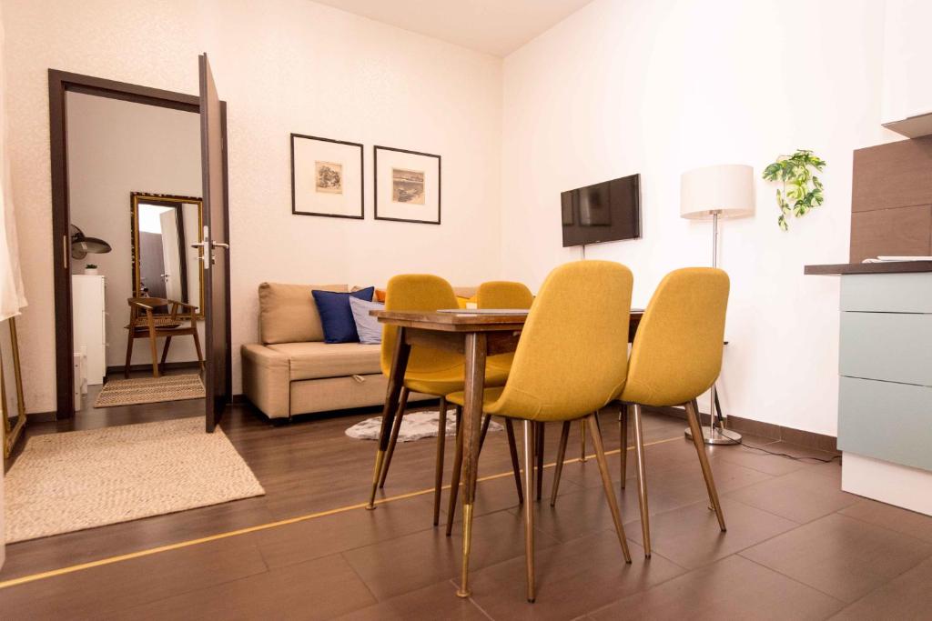 ブダペストにあるPaulay Design Apartmentのダイニングルーム(テーブル、黄色い椅子付)