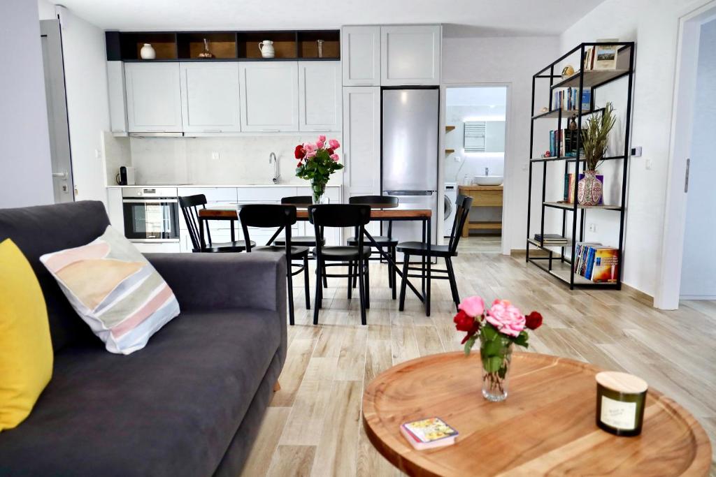 uma sala de estar com um sofá e uma mesa com flores em GK - Modern Apartment em Lepanto