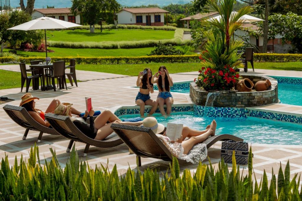 HOTEL YANUBA CAMPESTRE في بيريرا: مجموعة نساء جالسات على كراسي في مسبح