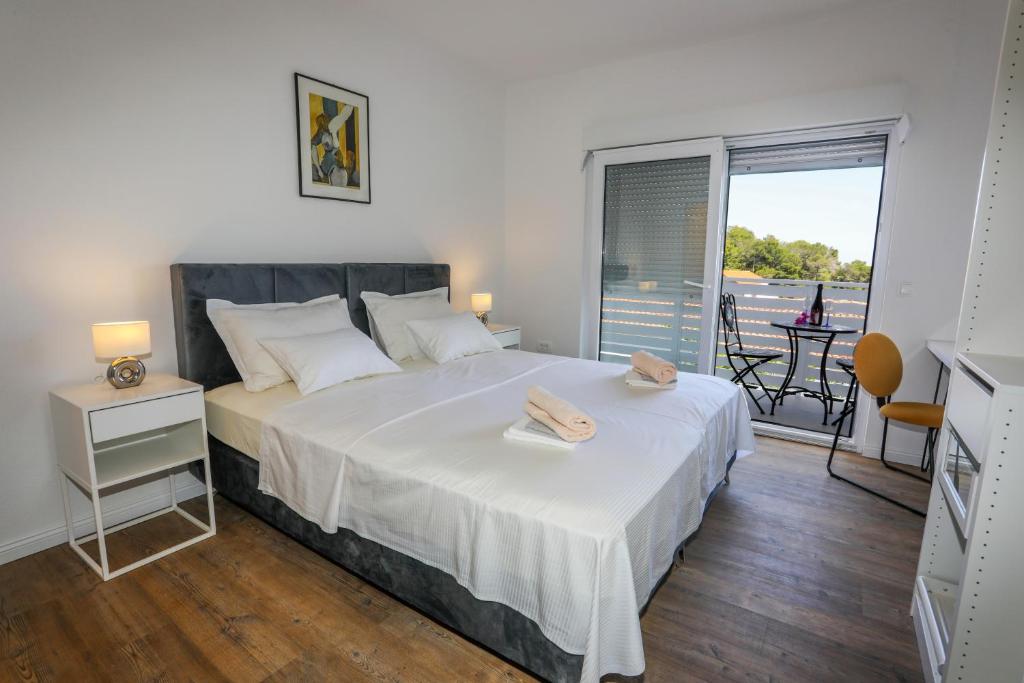 a bedroom with a large bed and a balcony at Stella Maris, Hvar - rooms with balcony and stunning sea views in Hvar