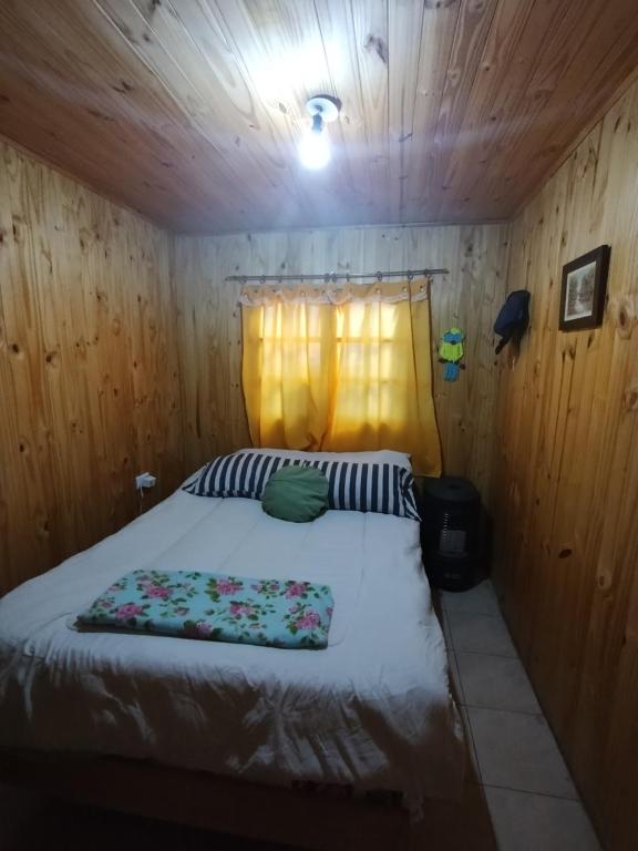 a bedroom with a bed in a wooden cabin at Cabañas Doña Beba in Cacheuta