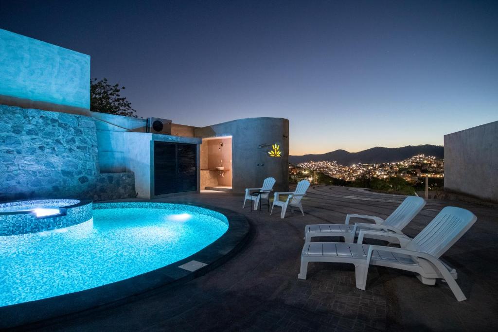 a patio with chairs and a swimming pool at night at Casa de Tillie in Guanajuato