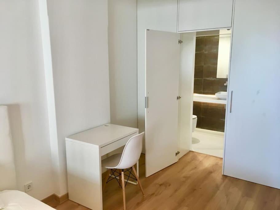 een witte kamer met een bureau en een stoel bij Lisbon South Bay Apartment with terrace in Almada