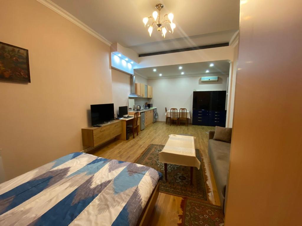 a bedroom with a bed and a living room at Studio apartment in Yerevan in Yerevan