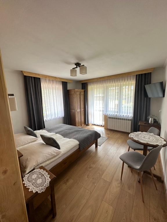 um quarto com uma cama grande e uma mesa em Willa Mango em Zakopane