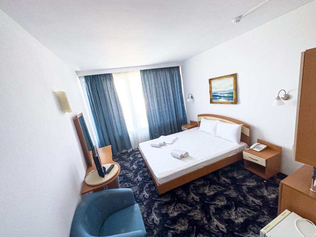 Hotel Sirena في ساتورن: غرفه فندقيه بسرير وكرسي ازرق