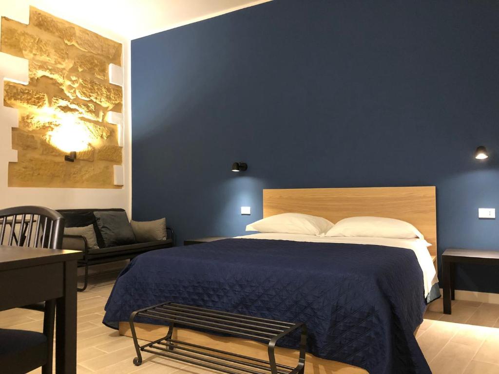 a bedroom with a bed with a blue wall at Kalé Atenea in Agrigento