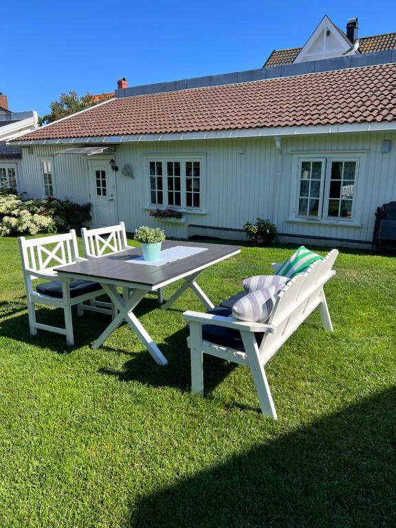 una mesa de picnic y dos sillas en un patio en Koselig maritim leilighet sentralt i Stavern, en Stavern