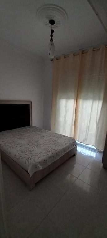 1 cama en un dormitorio con ventana en Dar lbhar, en Kelibia