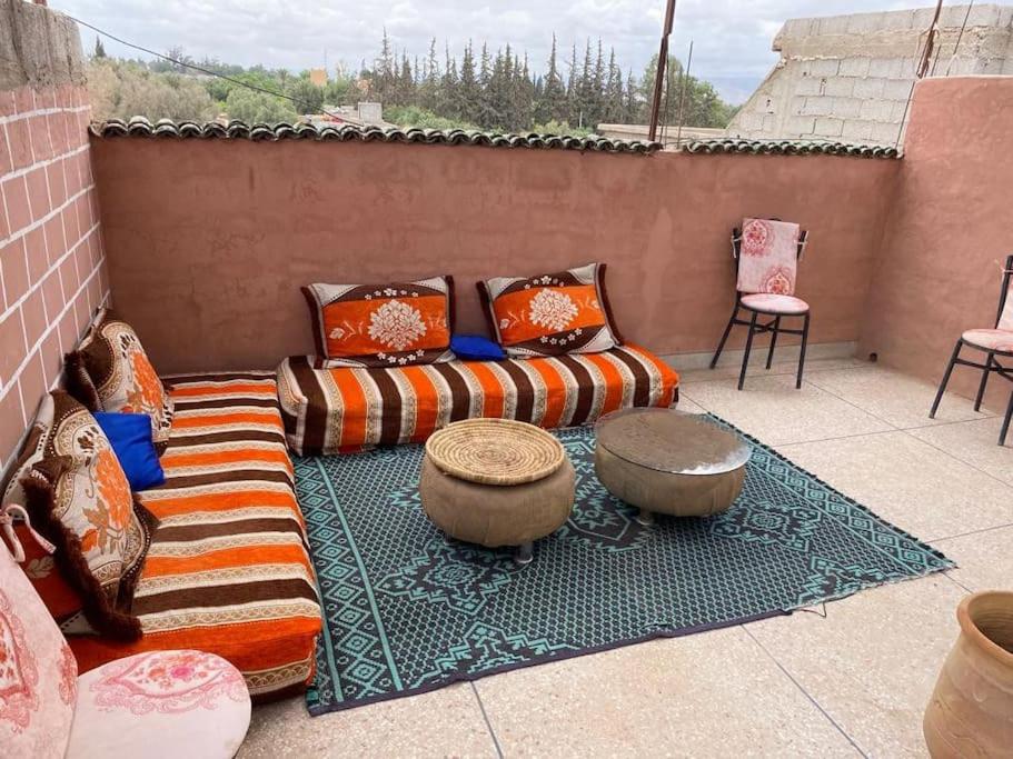 un patio con divano e 2 tavoli e sedie. di Dar Lala Fouzia a Taroudant