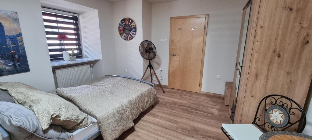 a bedroom with a bed and a fan in it at Apartma Rešer in Črna na Koroškem