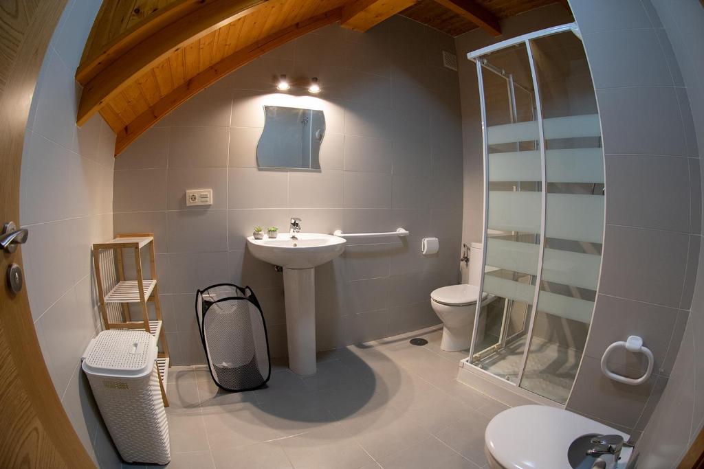 ein Bad mit einem Waschbecken, einem WC und einer Glasdusche in der Unterkunft Apartamento Tiver in Ribadeo
