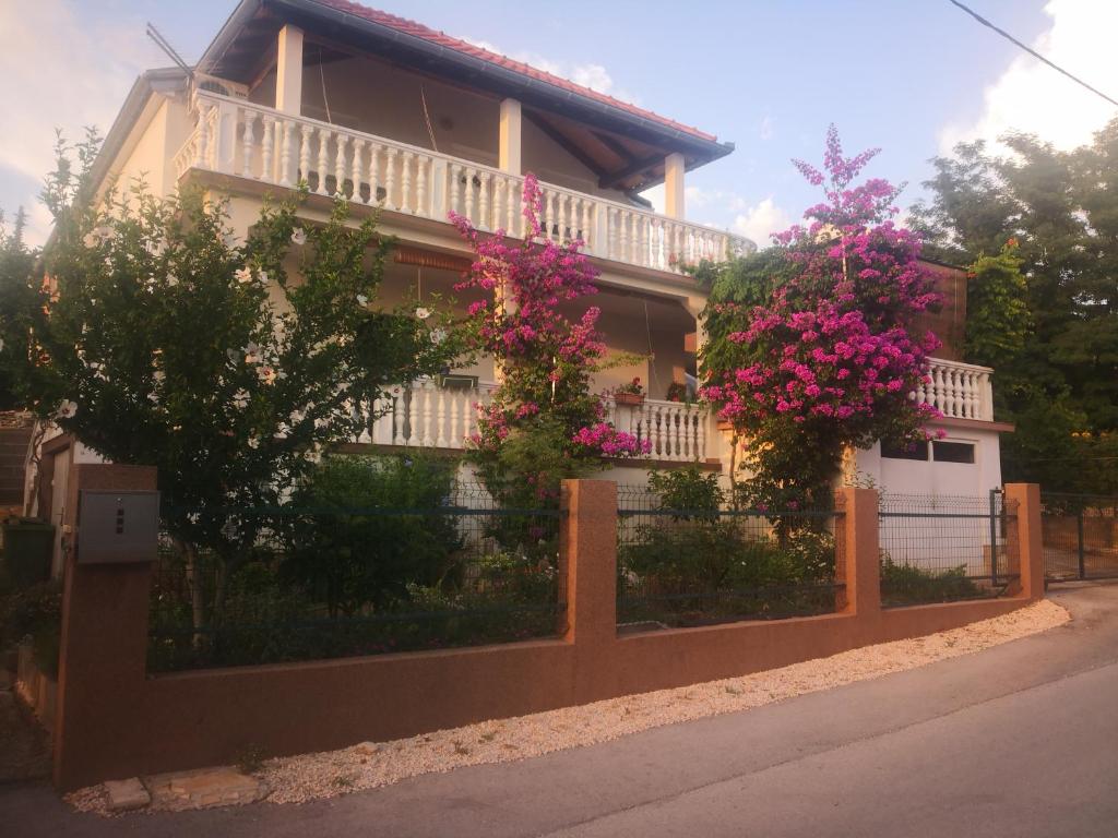 une maison avec une clôture ornée de fleurs dans l'établissement Apartment Ana, à Gornji Karin