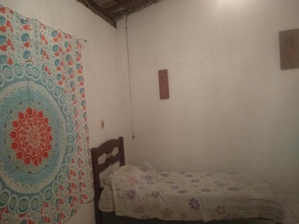 a small bedroom with a bed and a curtain at Chácara lua e Sol in Pouso Alegre