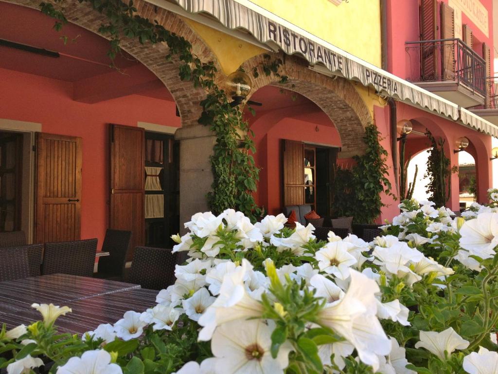 a table with white flowers in front of a building at Albergo Ristorante La Rocca in Firenzuola