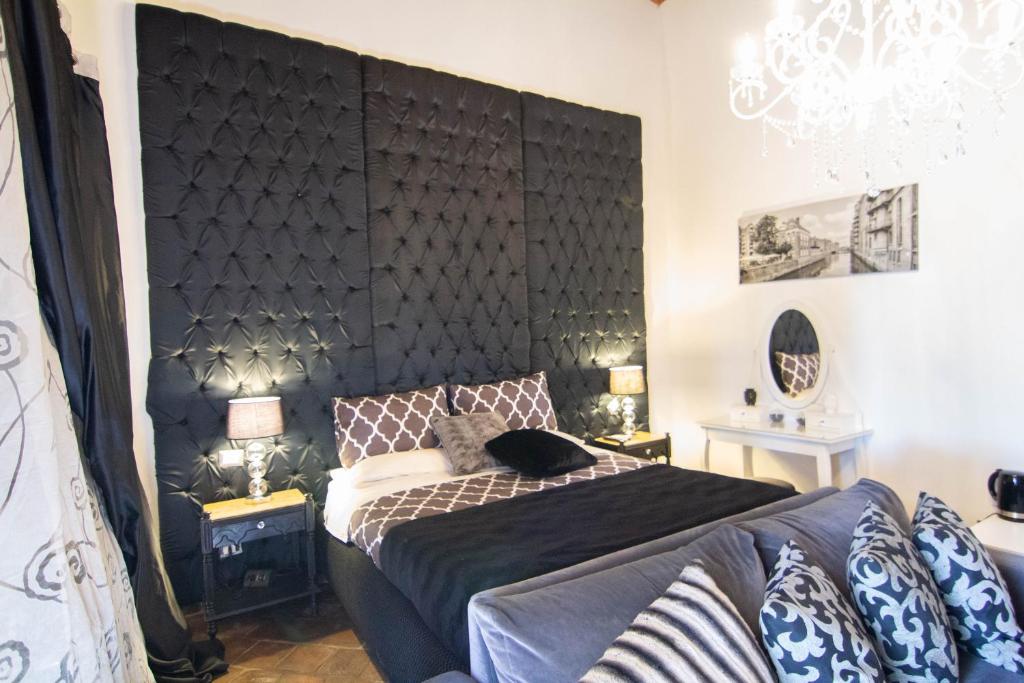 カターニアにあるLa Corte Della Reginaのベッドルーム(大きな黒いヘッドボード、ベッド1台付)