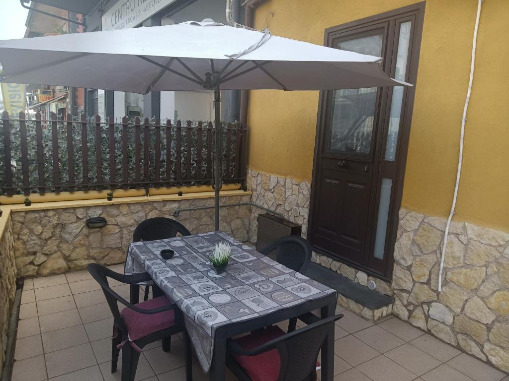 a table with an umbrella on a balcony at Delilah's house in Catania