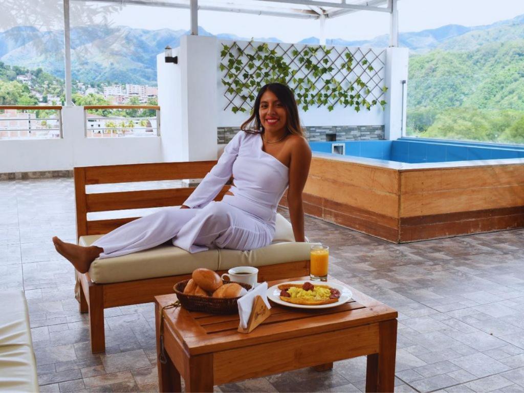 una mujer sentada en un banco con un plato de comida en HOTEL WISMONT, en La Merced
